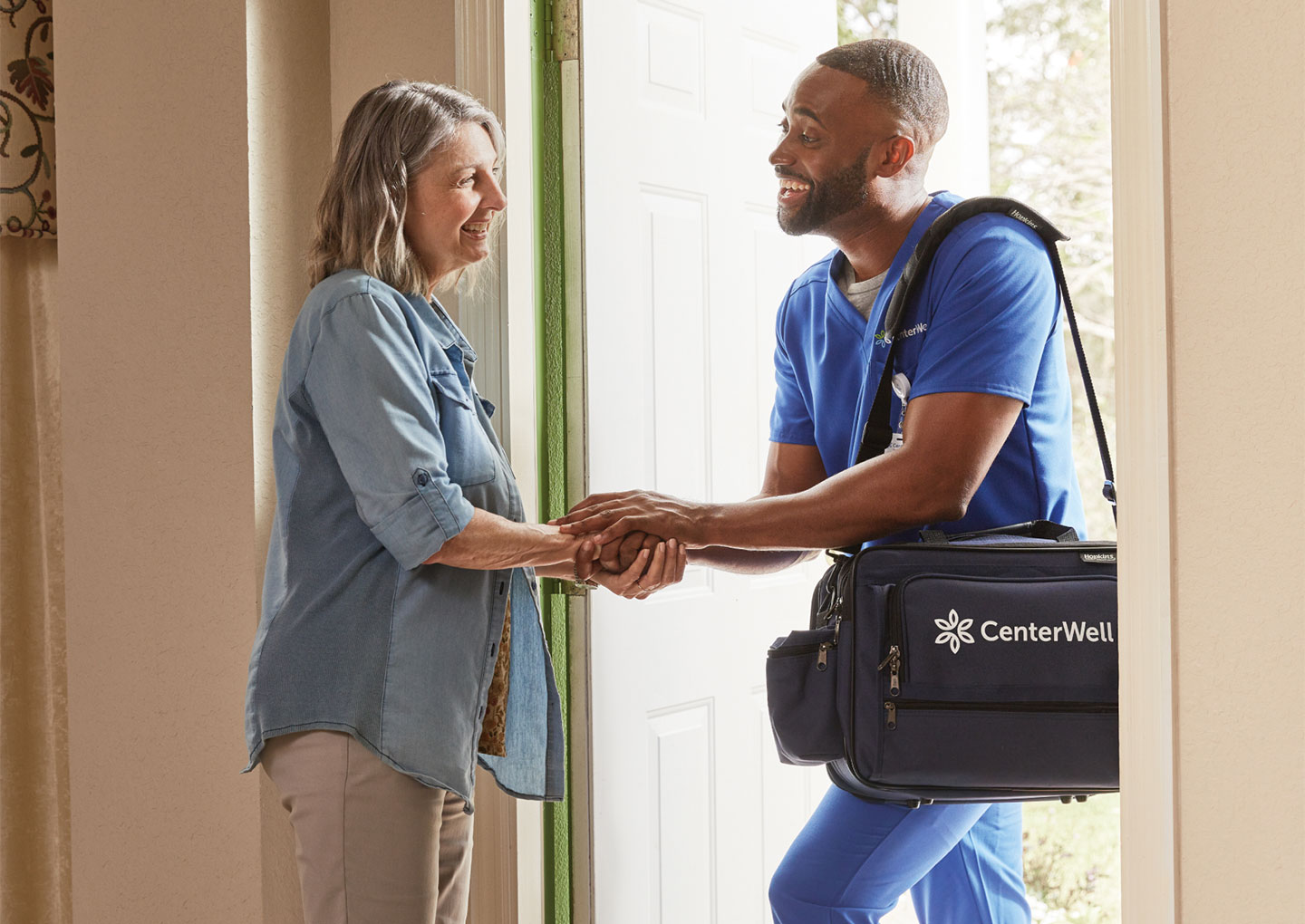 A CenterWell Home Health clinician warmly greeting a patient as he arrives at her home