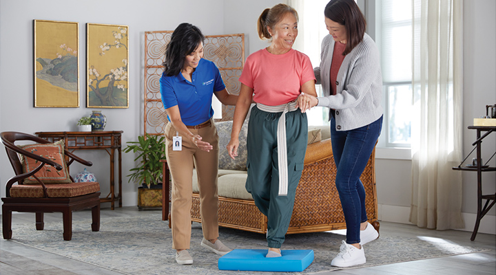 A CenterWell Home Health clinician working with a patient and a family member on balance issues in the patient's home